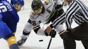 Brett Stovin taking a faceoff against the UBC T-Birds