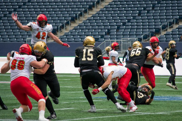 Bison quarterback Theo Deezar is sacked by an oncoming Calgary defender.