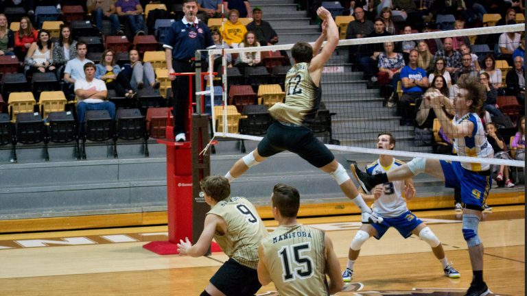Dustin Spiring goes for a block against the Brandon Bobcats