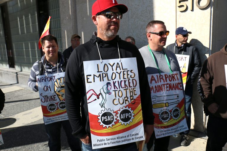 Hundreds of airport workers walk the line