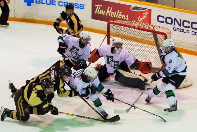 Bison forward Sheridan Oswald battles in front of the net against the Saskatchewan Huskies.