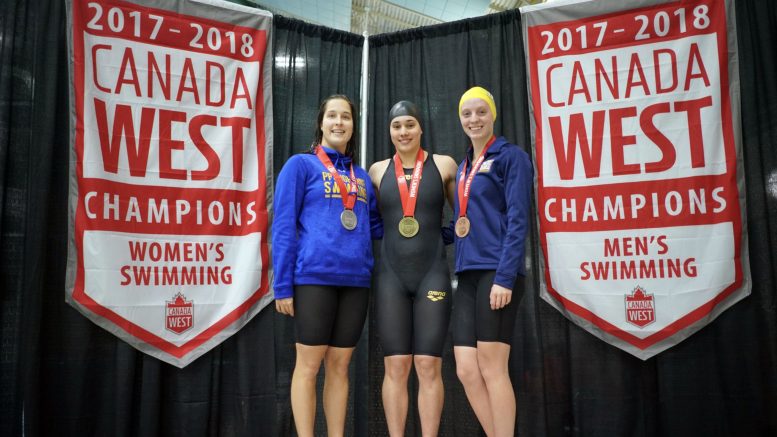 Bison swimmer Kelsy Wog (middle) with one of three of her gold medals at the Canada West Swimming championships in Victoria. Wog was also named Female Swimmer of the Meet.